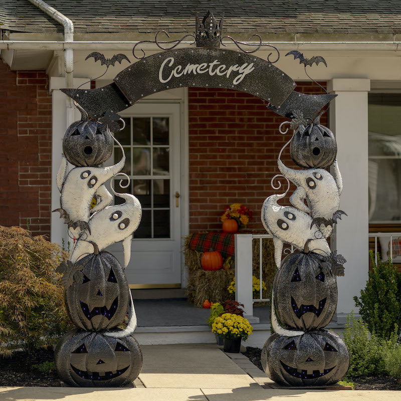 Halloween archway with pumpkins, ghosts and bats on sides and banner with marquee lights and the word "cemetery" across the top of the arch.