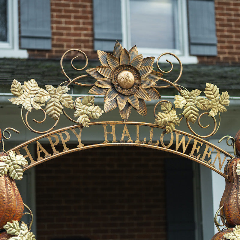 "Happy Halloween" lettering arching the top of the Halloween archway. Iron details of gold maple leafs and flower on top of lettering.