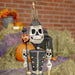 Front view close up of skeleton soldier with pumpkin staff. Big smile with lots of teeth, skeleton shoulders and black soldier coat with gold buckles.